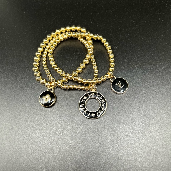 3 LV zipper pull charms on a 3 set gold color stretchable brac… - Picture 4 of 5